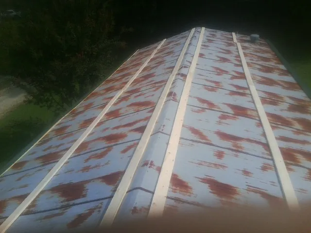 Rusted metal roof panels with new wood purlins before replacement — Storm Damage Roof Repair in Cedar Grove by Roofing Brothers