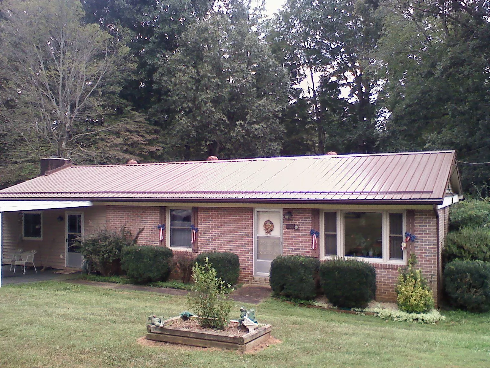 Bronze metal roof on a brick ranch home with a carport in Cedar Grove